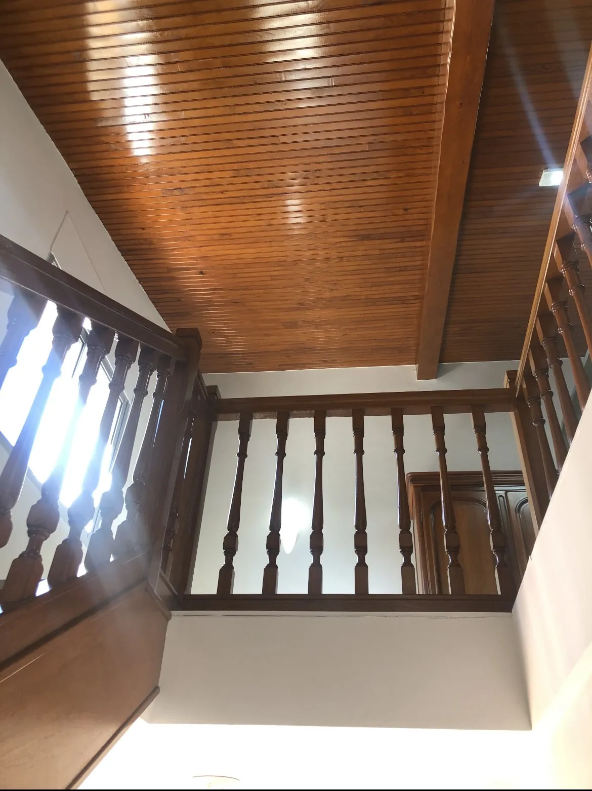 Plafond en lambris et garde-corps à balustres en bois teinté